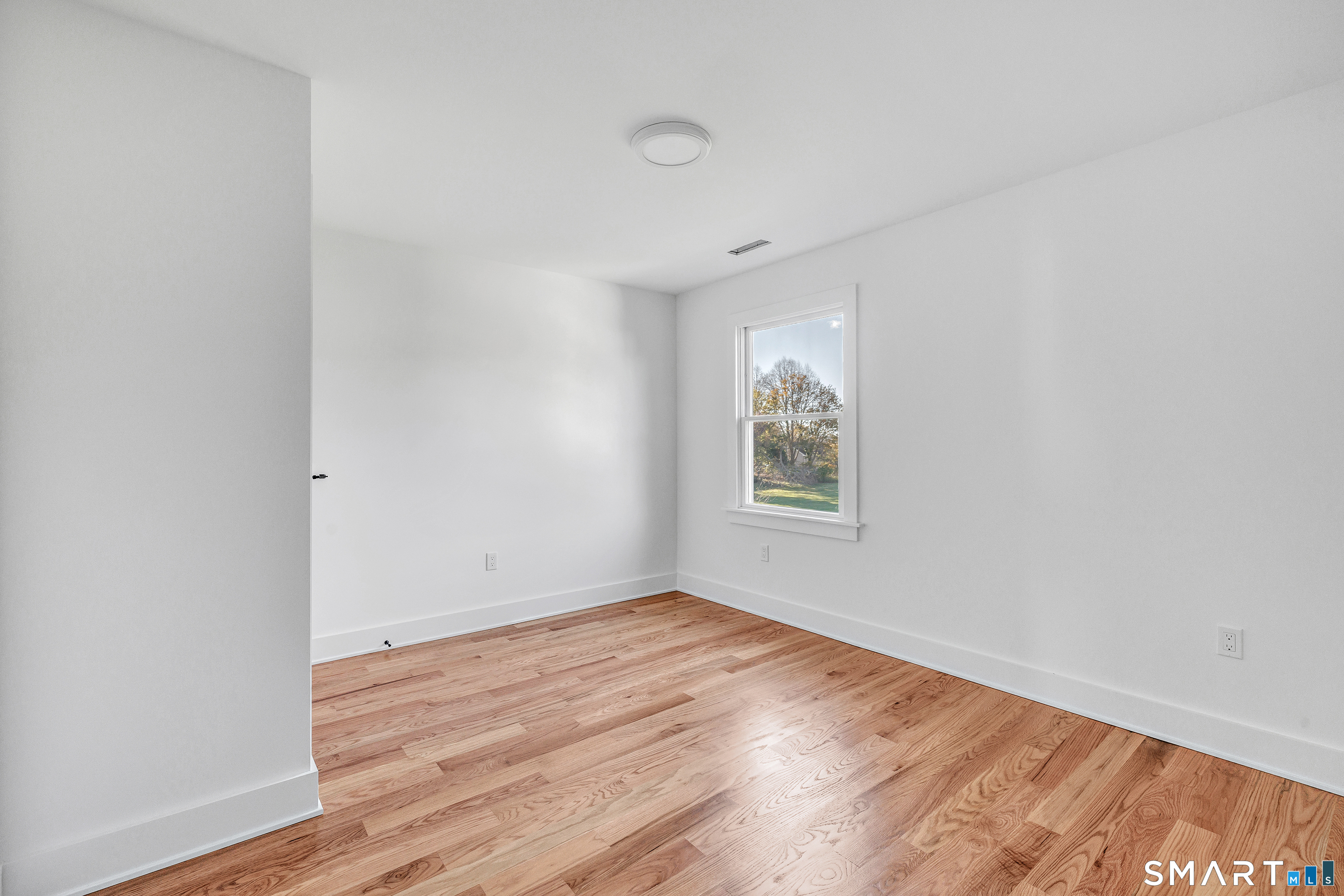 212 Milford Point Road Milford, CT 06460 - Photo 31 of 40 an empty room with wooden floor and windows