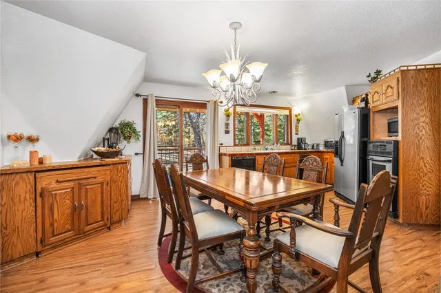 a dining room with furniture a chandelier and wooden floor