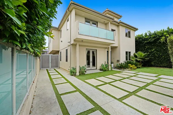 a view of a white house with a yard and plants