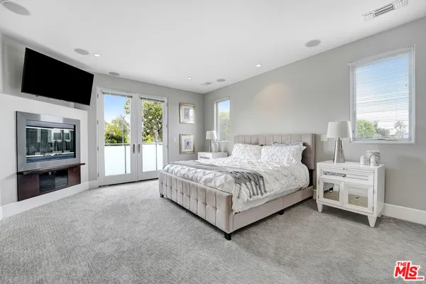 a spacious bedroom with a bed and a chandelier