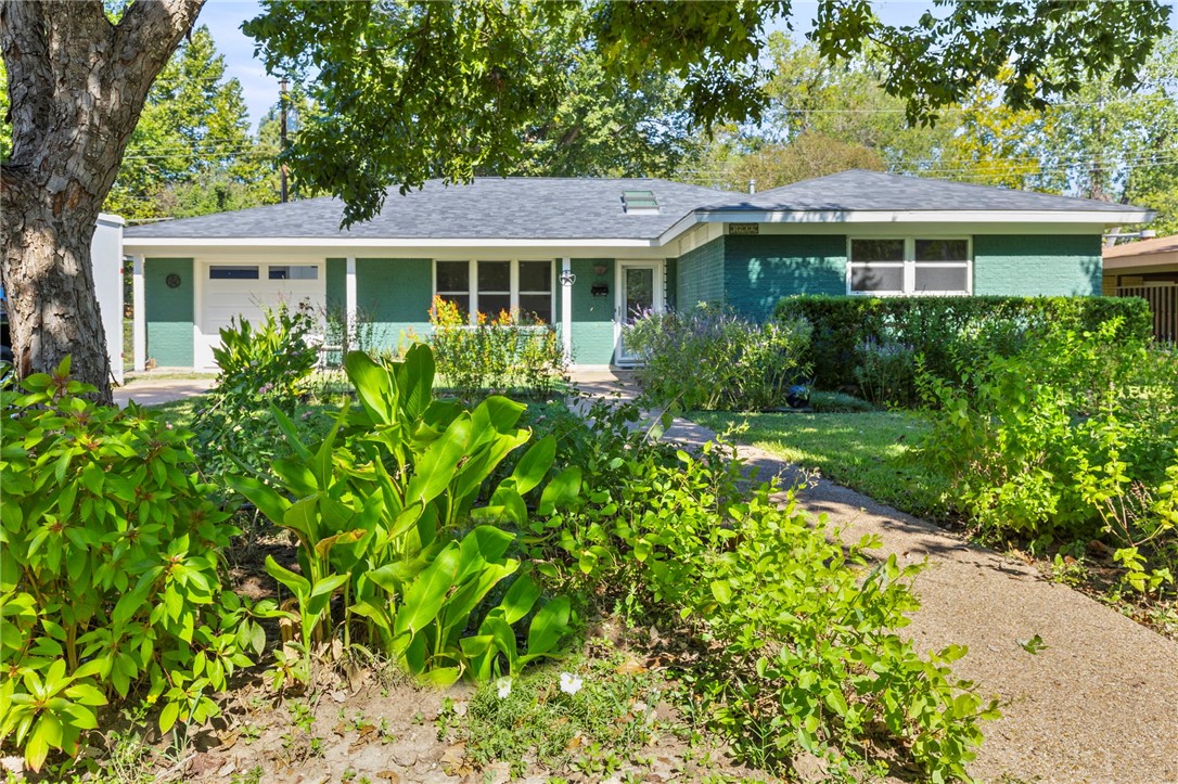 a front view of a house with a garden