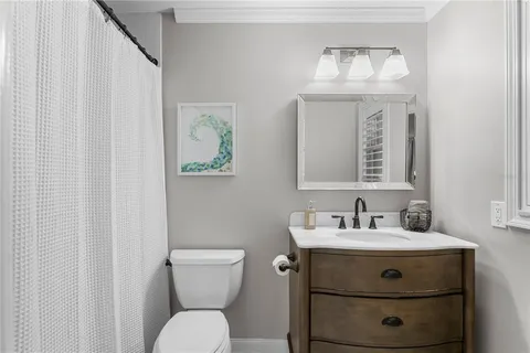 a bathroom with a sink mirror and toilet