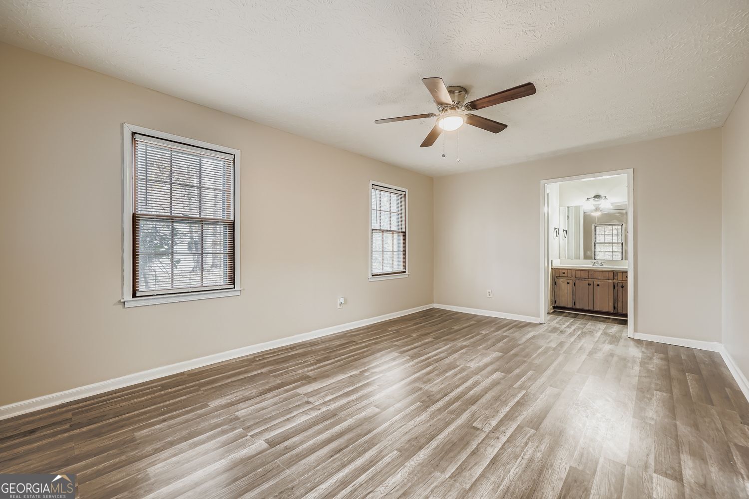 2932 Marsh Lane Southwest Stone Mountain, GA 30087 - Photo 6 of 11 a view of empty room with wooden floor and fan