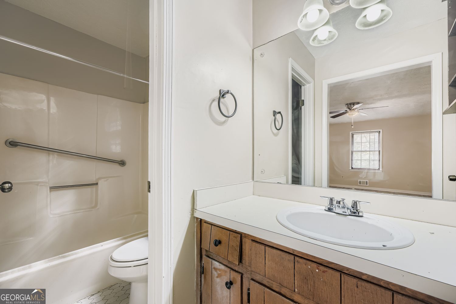 2932 Marsh Lane Southwest Stone Mountain, GA 30087 - Photo 7 of 11 a bathroom with a granite countertop sink a toilet a mirror and shower