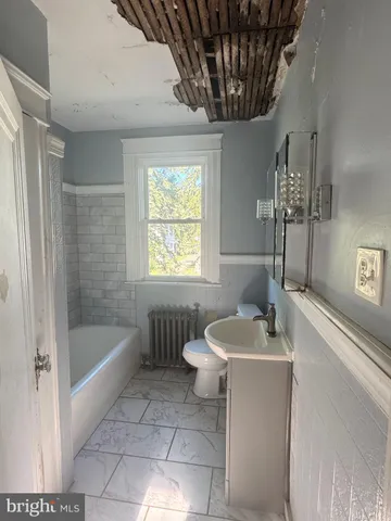 a bathroom with a sink a toilet a bathtub and shower
