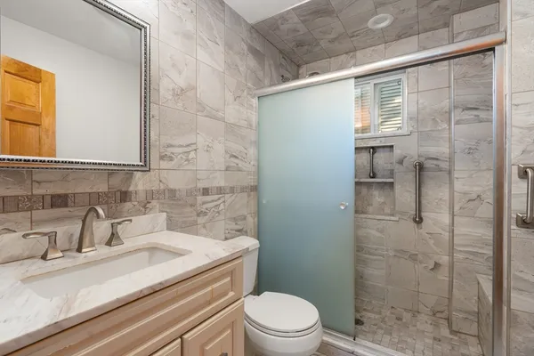 a bathroom with a sink a toilet and shower