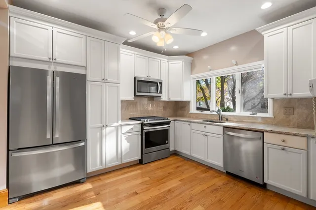 a kitchen with stainless steel appliances granite countertop a refrigerator a stove a sink and a microwave