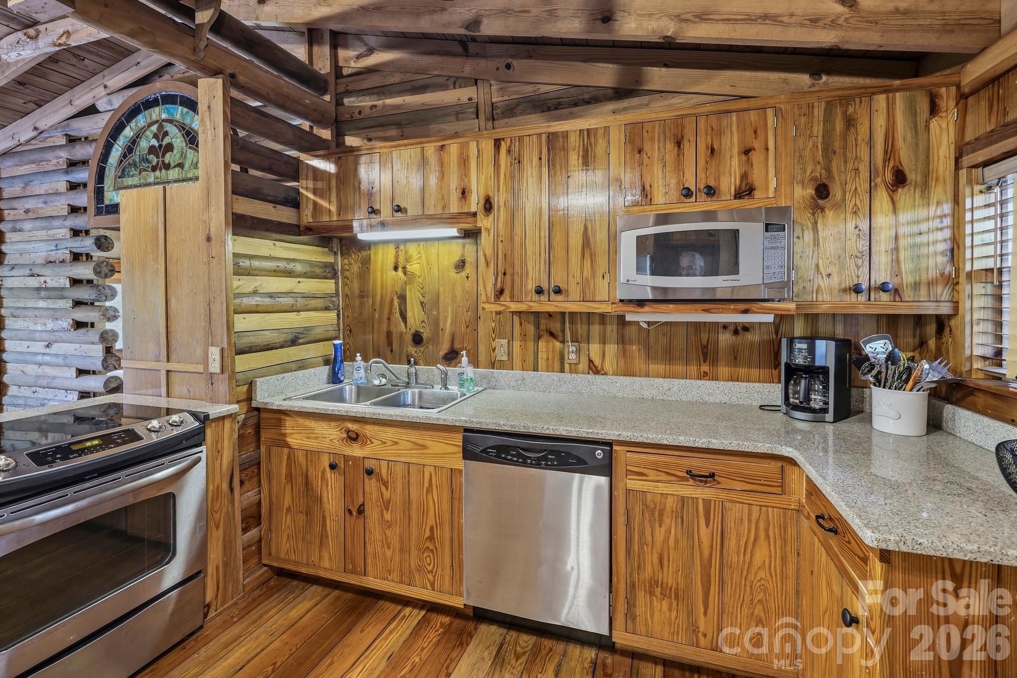 118 Rock Pt Road Lake Lure, NC 28746 - Photo 13 of 31 a kitchen with stainless steel appliances granite countertop a stove a sink and a microwave