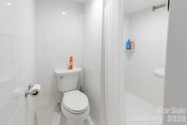 a bathroom with a toilet and a shower