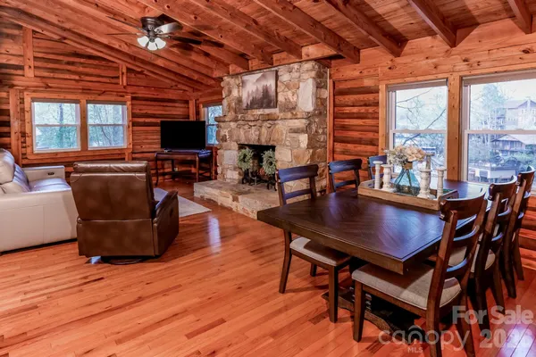 a living room with furniture a fireplace a flat screen tv and windows