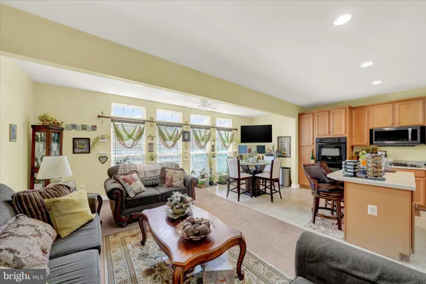 a living room with furniture and a flat screen tv with kitchen view