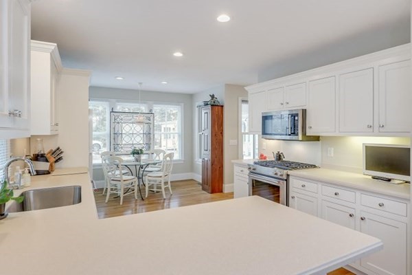 7 Cod Lane, Unit 7 Harwich, MA 02646 - Photo 17 of 41 a large white kitchen with white cabinets and stainless steel appliances