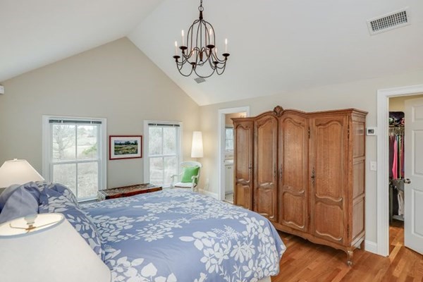 7 Cod Lane, Unit 7 Harwich, MA 02646 - Photo 29 of 41 a bedroom with a large bed and a chandelier
