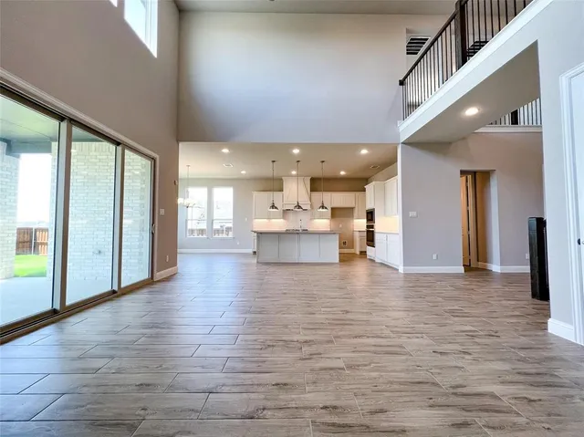 a large kitchen with stainless steel appliances granite countertop a stove and a wooden floor