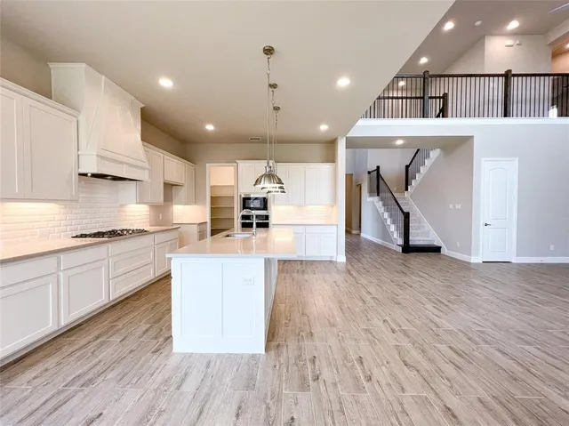 a large kitchen with stainless steel appliances kitchen island a large counter top a stove and a sink