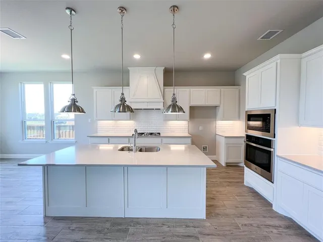 a large kitchen with stainless steel appliances granite countertop a large center island attached withe living room