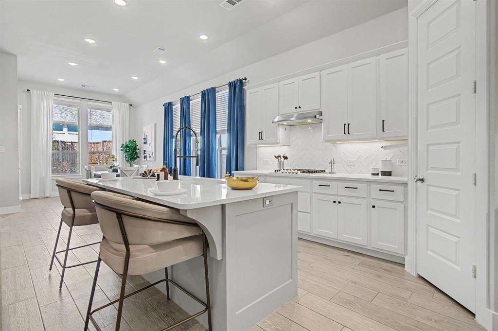 1101 Claiborne Drive Aubrey, TX 76227 - Photo 13 of 40 a kitchen with stainless steel appliances kitchen island granite countertop a sink and cabinets