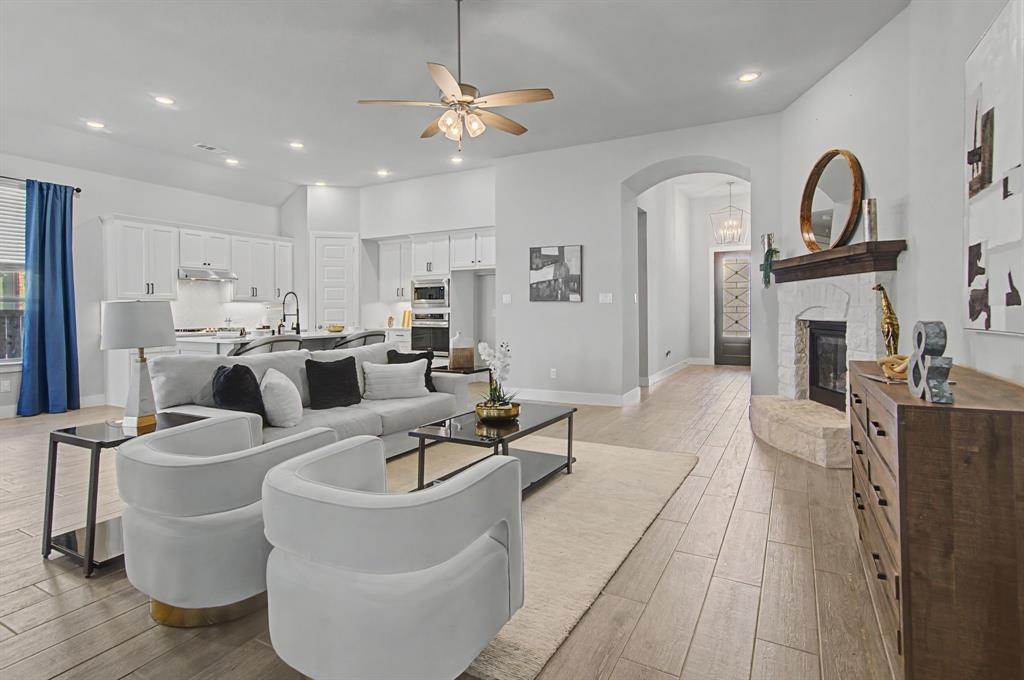 1101 Claiborne Drive Aubrey, TX 76227 - Photo 7 of 40 a living room with furniture a fireplace and kitchen view