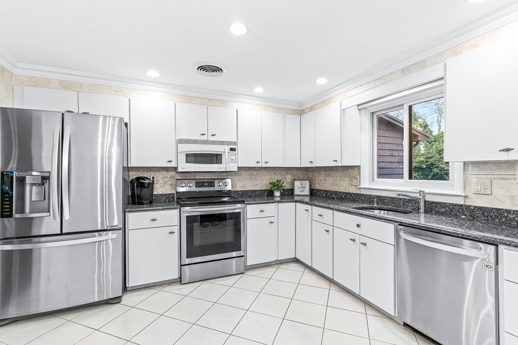 17 Gerald Road Marblehead, MA 01945 - Photo 4 of 36 a kitchen with granite countertop white cabinets and stainless steel appliances