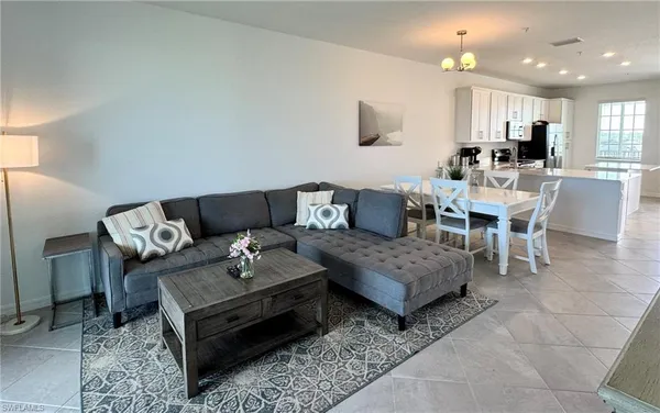 a living room with furniture and a dining table with kitchen view
