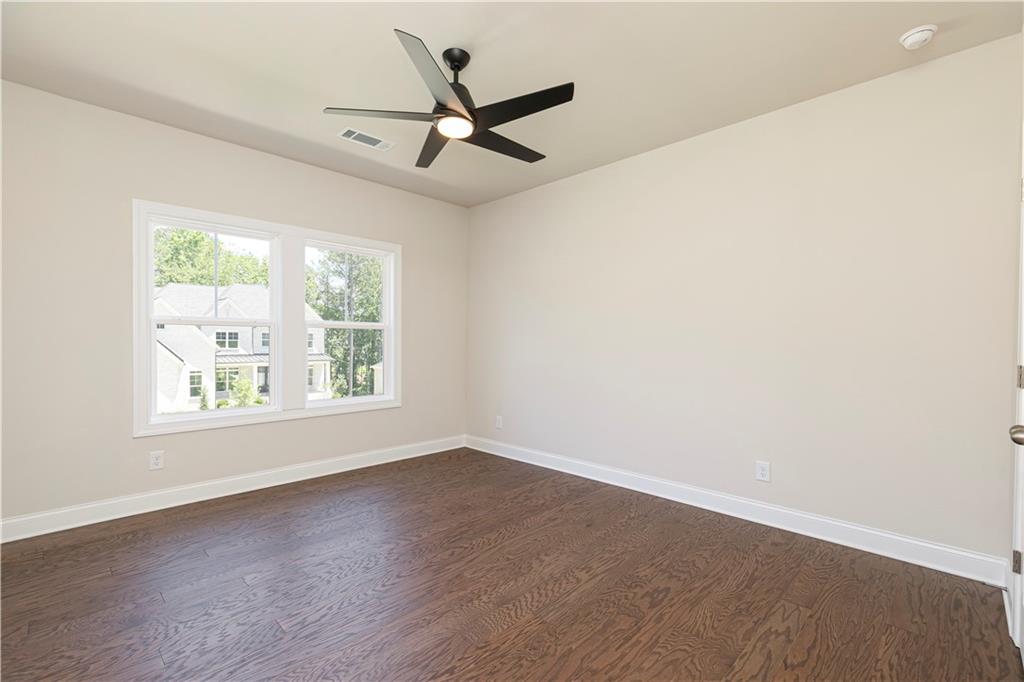 2475 Stewart Road Cumming, GA 30041 - Photo 23 of 30 an empty room with wooden floor fan and windows