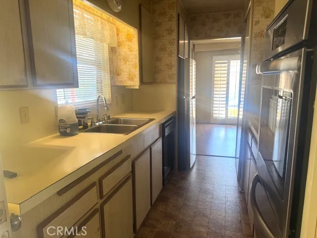 a kitchen with stainless steel appliances granite countertop a refrigerator a sink and a stove