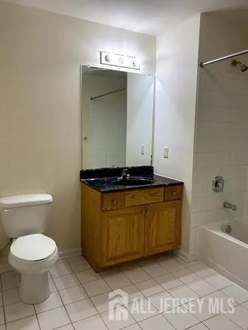 a bathroom with a granite countertop sink a mirror and a bathtub