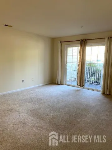 a view of a room with a hanging light and kitchen
