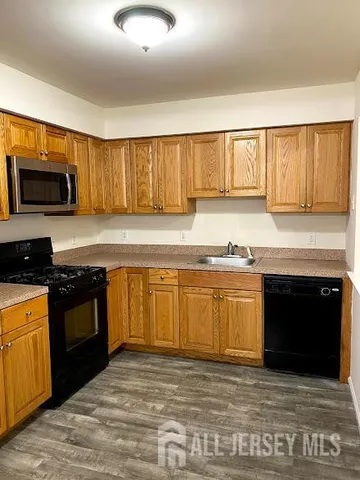 a kitchen with granite countertop a refrigerator stove and microwave