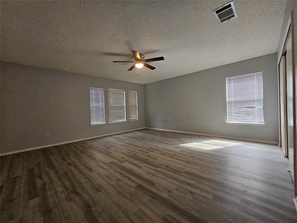 1113 Stillwell Ridge Cedar Park, TX 78613 - Photo 25 of 32 an empty room with wooden floor chandelier fan and windows