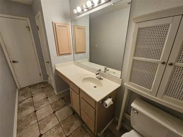 a bathroom with a sink toilet and mirror
