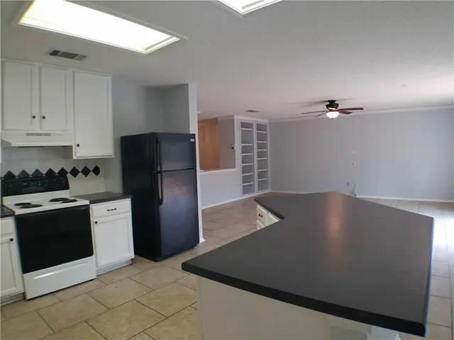 a view of a kitchen with a stove top oven and cabinets