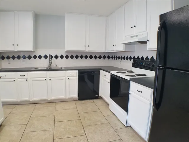a kitchen with a stove sink and cabinets