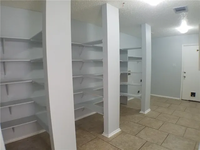 a view of walk in closet with empty racks