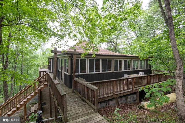 a view of a wooden deck and a yard with swimming pool