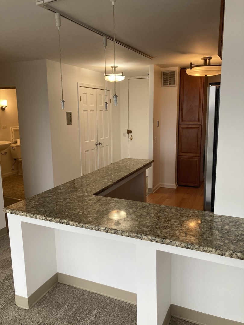 5445 North Sheridan Road, Unit 1409 Chicago, IL 60640 - Photo 5 of 7 a view of kitchen island a sink wooden floor and kitchen view