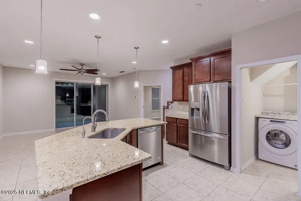 a kitchen with stainless steel appliances granite countertop a refrigerator a sink and a stove