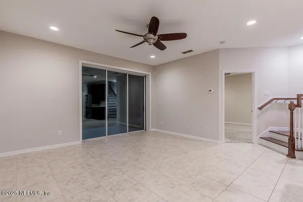 a view of an empty room with a ceiling fan