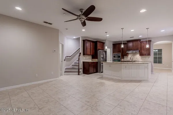 a large kitchen with stainless steel appliances kitchen island granite countertop a large counter top and a stove with kitchen island