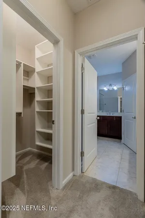 a view of a walk in closet and a living room