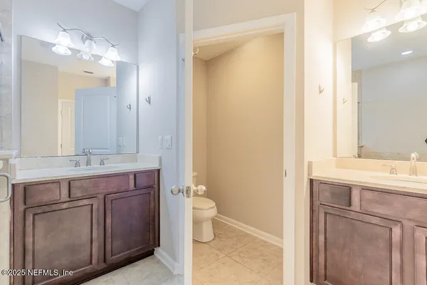 a bathroom with a granite countertop sink a toilet and a mirror