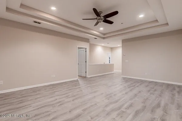 an empty room with windows and fan