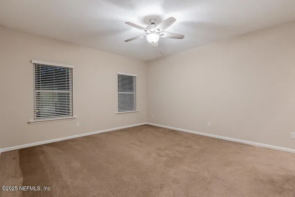 an empty room with closet and a chandelier fan