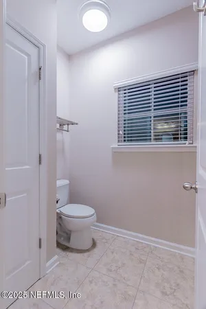 an empty room with a chandelier fan and closet area