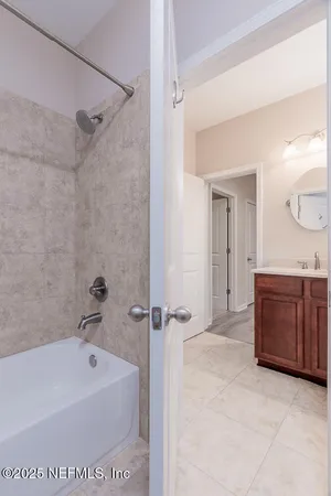 an empty room with windows and chandelier fan