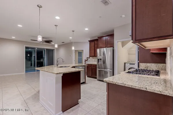 a large kitchen with kitchen island a sink stove and refrigerator