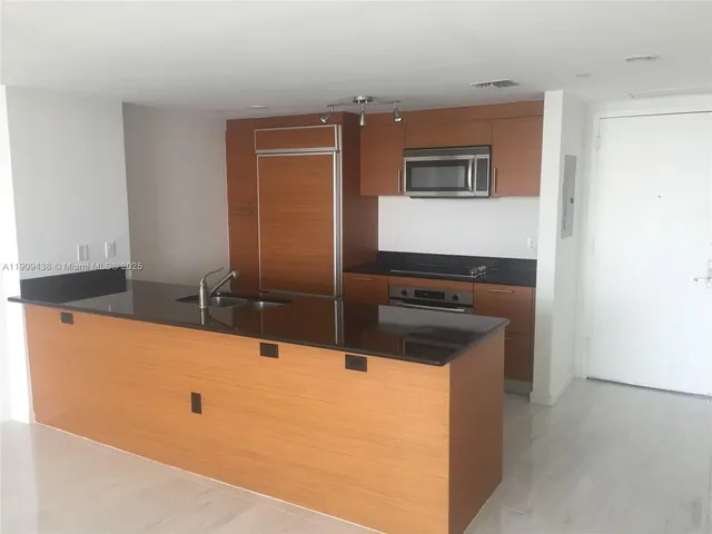 a kitchen with granite countertop a sink and cabinets