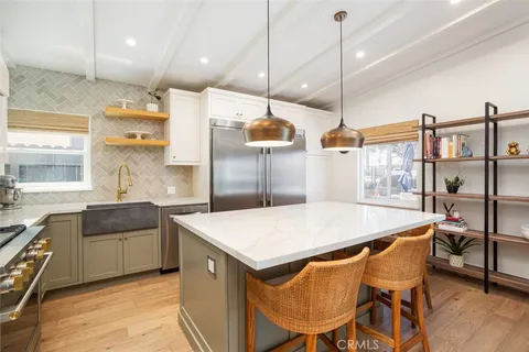a kitchen with a table chairs sink and wooden floor