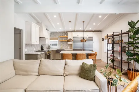 a living room with furniture and a view of kitchen
