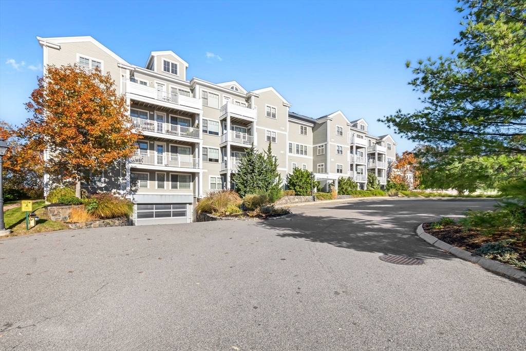 a view of a street with a building and couple of cars parked in front of it